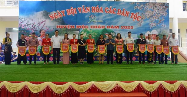 Ban Tổ chức trao Cờ lưu niệm cho các xã tham gia Ngày hội Văn hóa các dân tộc huyện Mộc Châu năm 2022. 