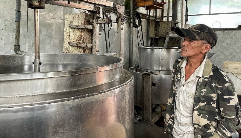 Ông Nguyễn Hữu Cường bên máy nấu tương do ông chế tạo, hoàn thiện dần sau 20 năm làm nghề.
