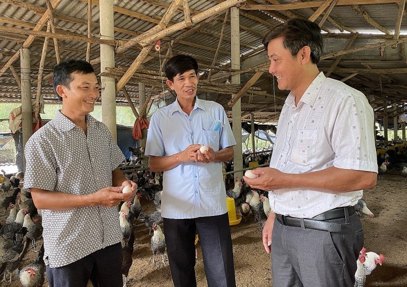 Anh Trí (bìa trái) giới thiệu sản phẩm từ gà với lãnh đạo xã Mỹ Đức