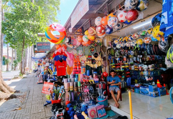 Dãy cửa hàng bán đồ thể thao trên đường Huyền Trân Công Chúa (quận 1, TP.HCM) vắng khách, nhiều người bán hàng lướt điện thoại giết thời gian