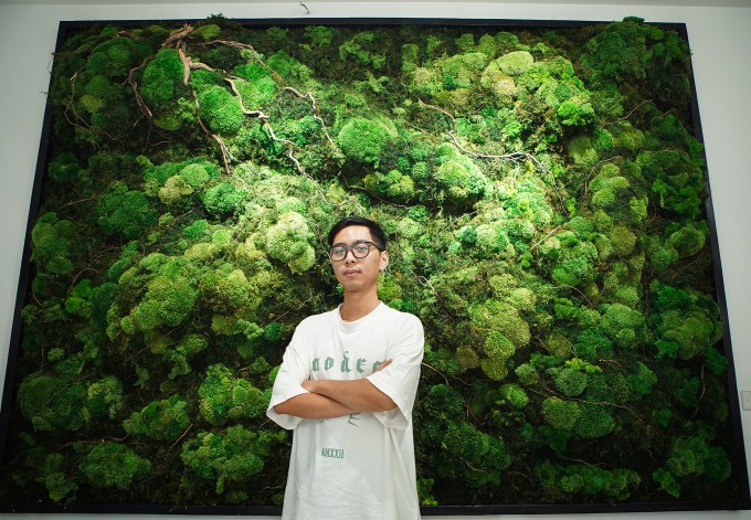 Anh Tuấn Anh cùng bức tranh rêu bảo tồn dài 2 m vừa hoàn thiện tại cửa hàng trên đường Hồ Đắc Di