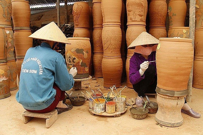 Các nghệ nhân đang trang trí hoa văn trên các sản phẩm gốm Các nghệ nhân đang trang trí hoa văn trên các sản phẩm gốm