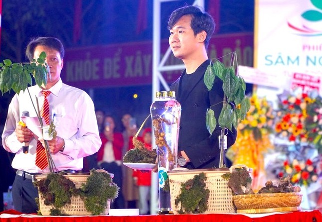 Du khách Nguỵ Hoàng Tây (áo đen) đã mua được củ sâm Ngọc Linh lớn nhất tại phiên đấu giá. Ảnh: Nguyễn Dung.