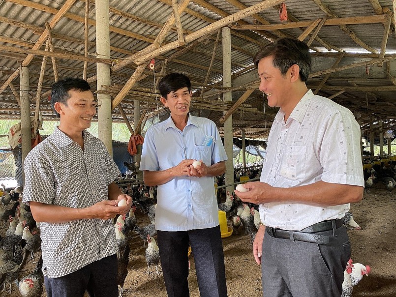 Anh Trí (bìa trái) giới thiệu sản phẩm từ gà với lãnh đạo xã Mỹ Đức
