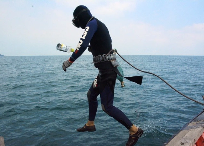 Sau khi mặt đầy đủ dụng cụ, các thợ lặn nhảy xuống nước