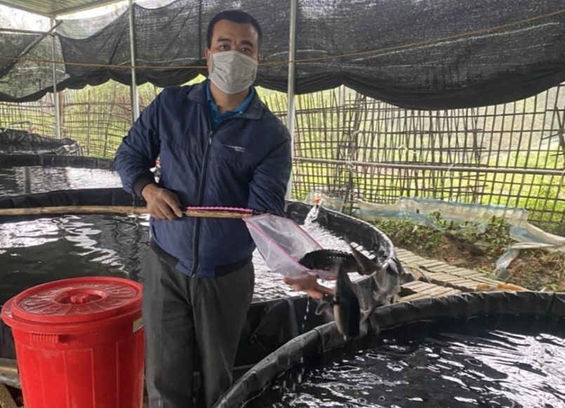 Anh Bùi Bích Phong bên trại cá tầm