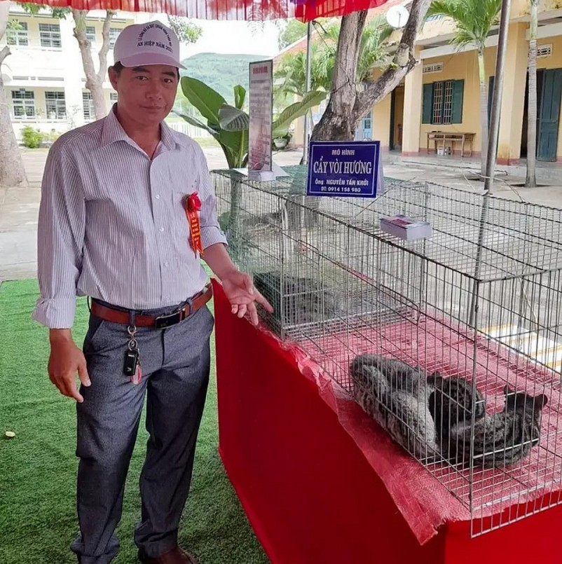 Anh Nguyễn Tấn Khởi bên chồn hương (cầy vòi hương) của gia đình.