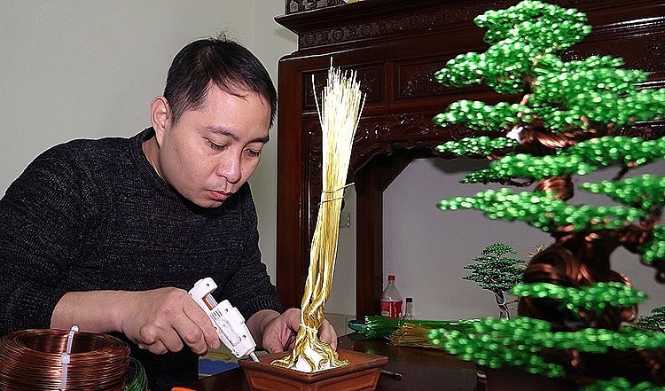 Anh Phạm Văn Doanh sử dụng dây đồng tạo thế thân cây. Anh Phạm Văn Doanh sử dụng dây đồng tạo thế thân cây.