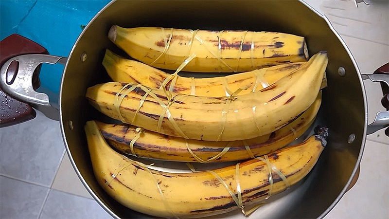 Lấy dây nylon quấn quanh chuối trước khi luộc