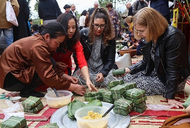 Du khách trải nghiệm làm bánh chưng. Ảnh: Quang Vinh.