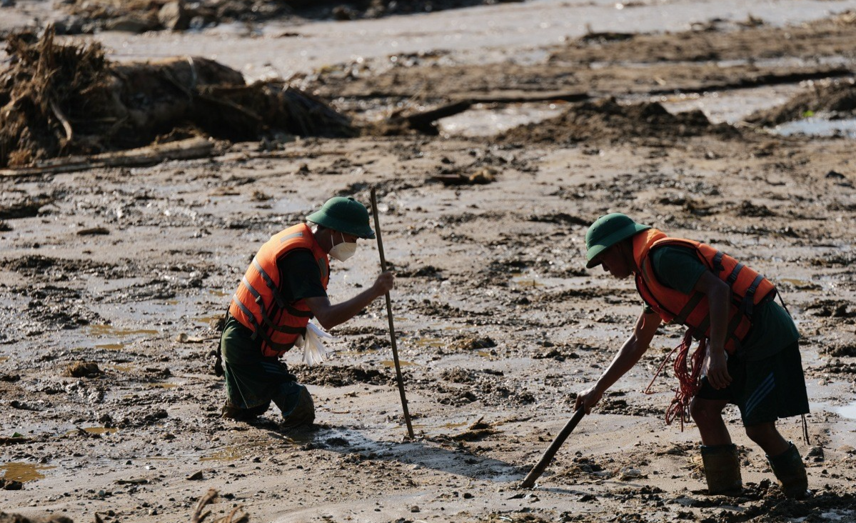 các chiến sĩ vẫn phải mặc áo phao, dầm mình trong bùn lầy chọc que dò tìm. các chiến sĩ vẫn phải mặc áo phao, dầm mình trong bùn lầy chọc que dò tìm.