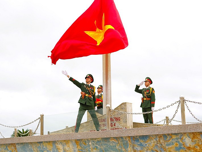 Quốc kỳ được kéo lên, đội tiêu binh giữ tư thế nghiêm trang, mọi ánh mắt hướng về lá cờ với niềm tự hào