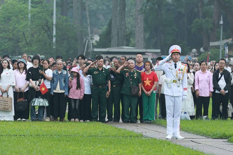 Nhiều người dân đứng nghiêm trang, mắt hướng về quốc kỳ đang tung bay trong gió. Tất cả cùng cất vang tiếng hát Quốc ca, hòa chung niềm tự hào và xúc động trong ngày lễ trọng đại 30/4.