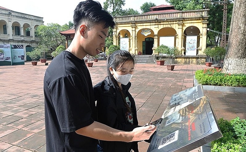 Du khách quét mã QR để tìm hiểu thông tin tại Di sản văn hóa thế giới Hoàng thành Thăng Long (Hà Nội).