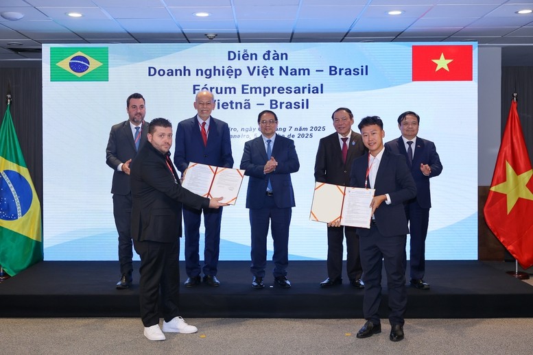 Thủ tướng Phạm Minh Chính và các đại biểu chứng kiến lễ trao thỏa thuận hợp tác giữa Công ty Cổ phần Nam Việt (NAVICO) và AV09 Comercio Exporter Ltda trong lĩnh vực thủy sản - Ảnh: VGP