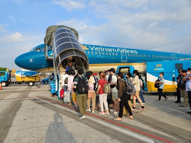 Hành khách lên chuyến bay của Vietnam Airlines. —Ảnh VNA/VNS