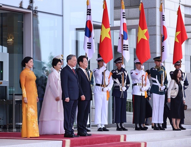 Tổng thống Hàn Quốc Lee Jae Myung và Phu nhân cùng Tổng Bí thư Tô Lâm và Phu nhân tại vị trí danh dự, nghe quân nhạc cử quốc thiều hai nước - Ảnh: TTXVN