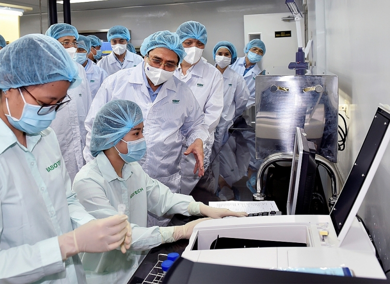 Thủ tướng Phạm Minh Chính thăm hỏi, động viên các nhà khoa học đang làm việc tại Viện Vệ sinh dịch tễ Trung ương và Công ty VABIOTECH. Ảnh: VGP/Nhật Bắc.