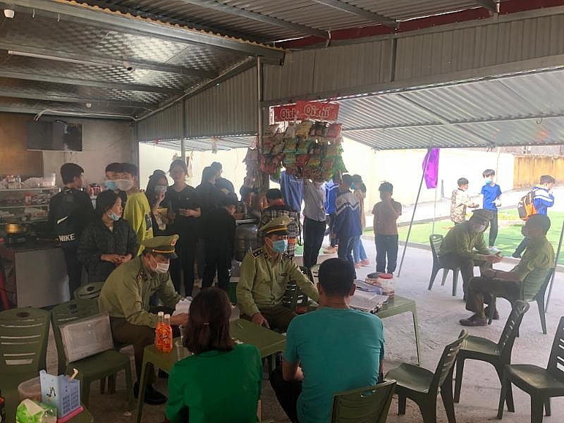 Đội QLTT số 2 lập hồ sơ xử phạt một hộ kinh doanh tại cổng trường học, ảnh: Huy Dương