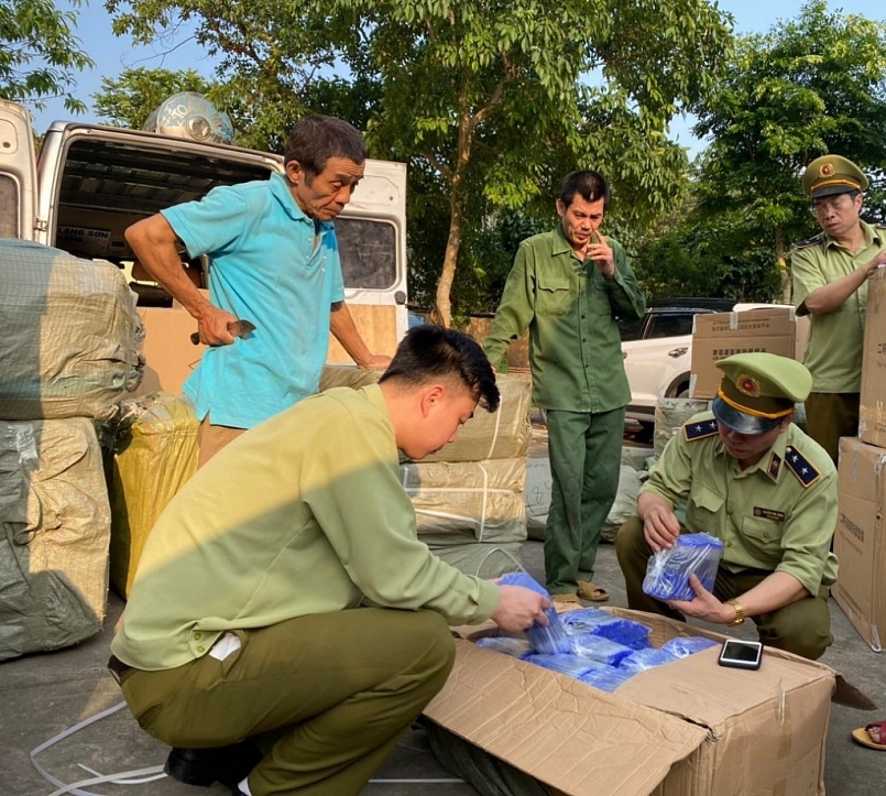 Lực lượng chức năng kiểm tra số hàng vi phạm. Ảnh: QLTT LS