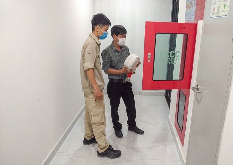 Anh Nam (áo caro) kiểm tra thiết bị PCCC ở một tòa nhà (ảnh tư liệu) Anh Nam (áo caro) kiểm tra thiết bị PCCC ở một tòa nhà (ảnh tư liệu)