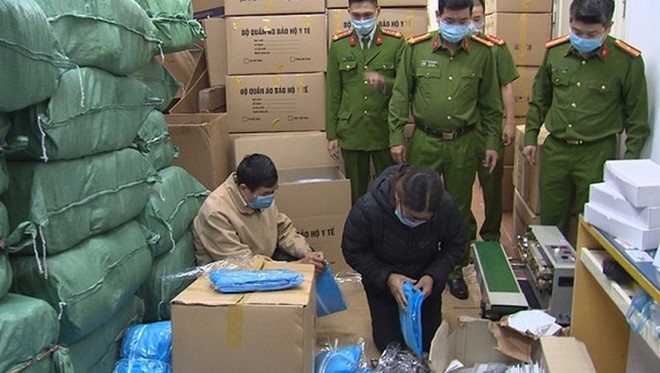 Cơ quan Công an khám xét kho hàng giả trang phục phòng, chống dịch COVID-19. (Ảnh: Báo CAND) Cơ quan Công an khám xét kho hàng giả trang phục phòng, chống dịch COVID-19. (Ảnh: Báo CAND)